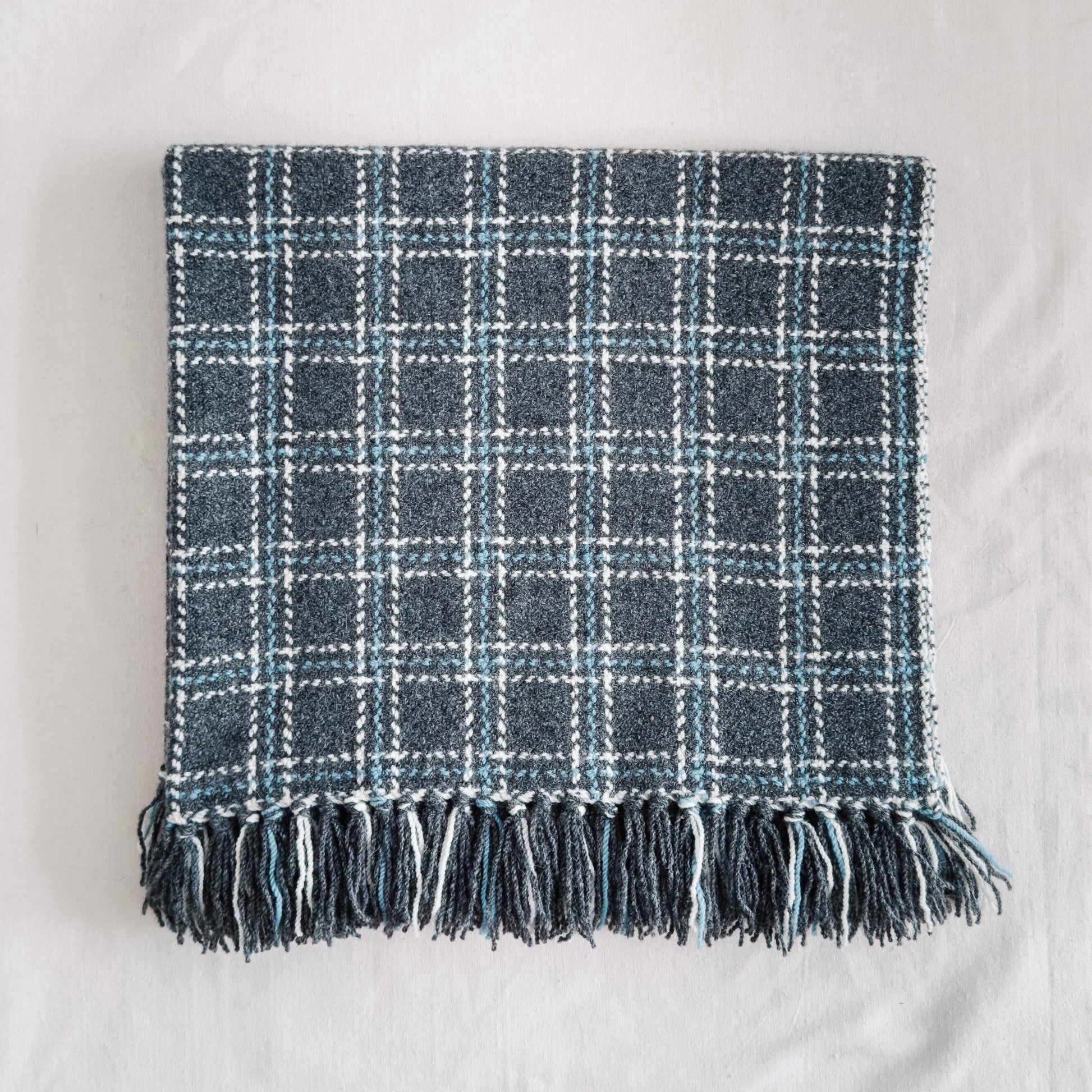 Plaid blanket with fringes on a white background
