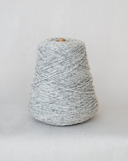 Spool of gray yarn on a light gray background