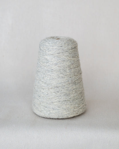 Spool of gray yarn on a light gray background