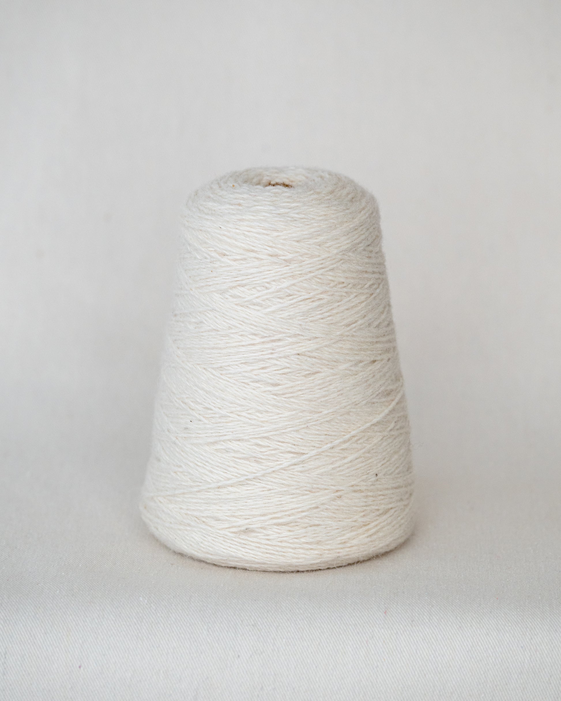 White yarn cone on a light gray background