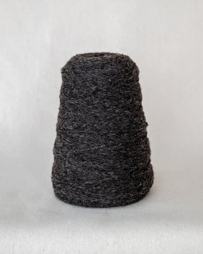 Dark gray skein of yarn on a light gray background